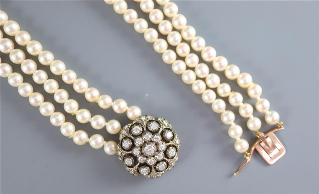 A modern triple row cultured pearl necklace with an earlier Victorian gold, silver and diamond cluster set clasp,